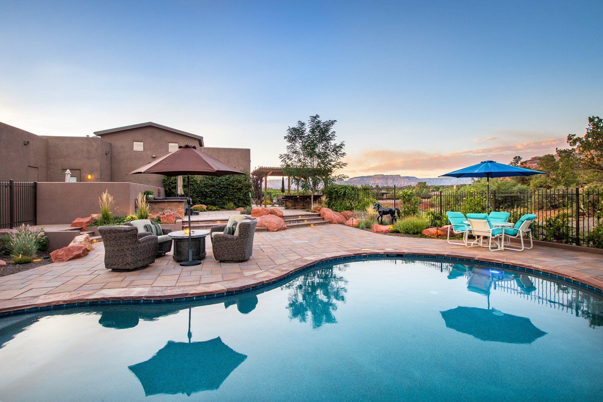 There is a large swimming pool in the backyard of a house.