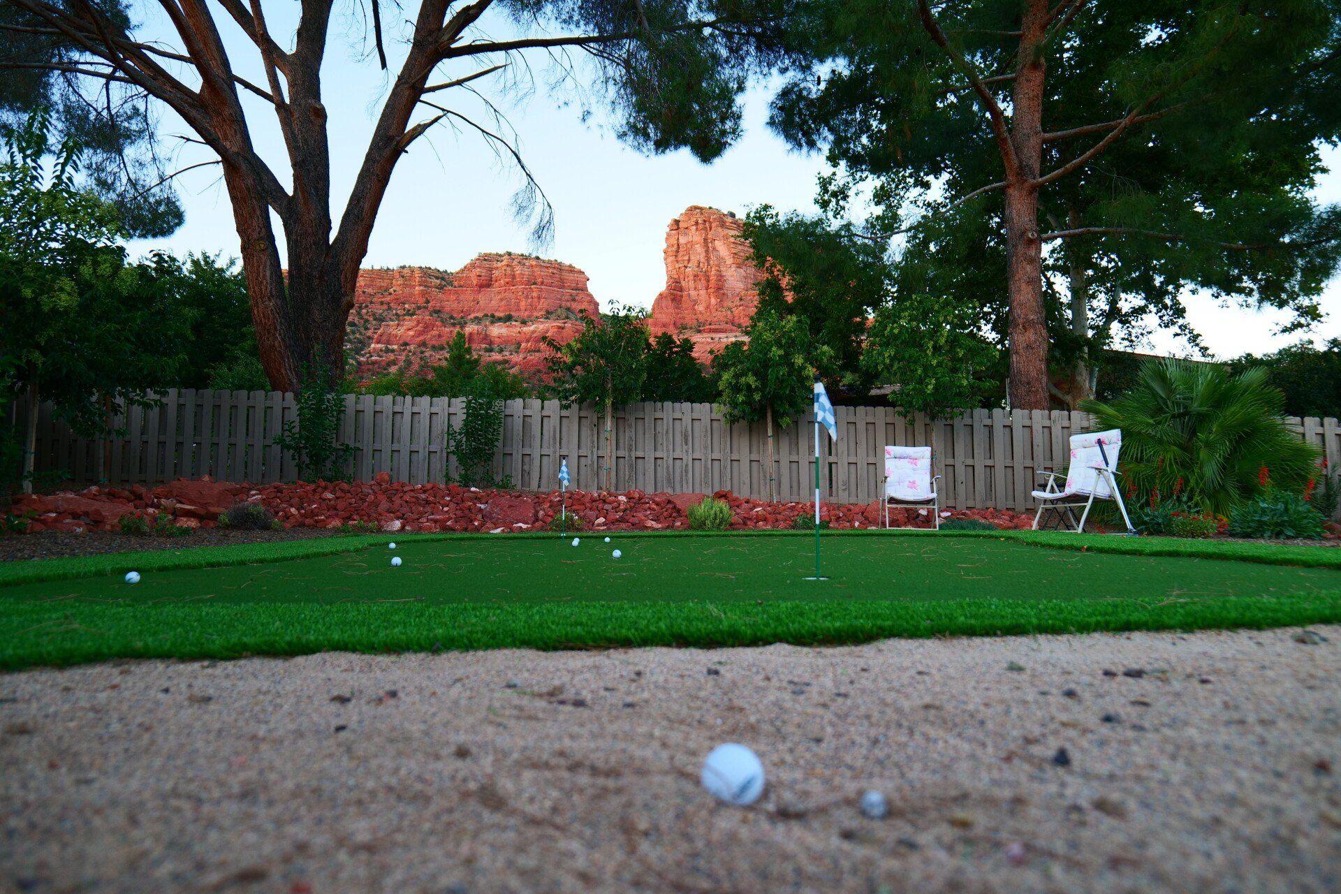 Maintained lawn and planting beds below the red rocks