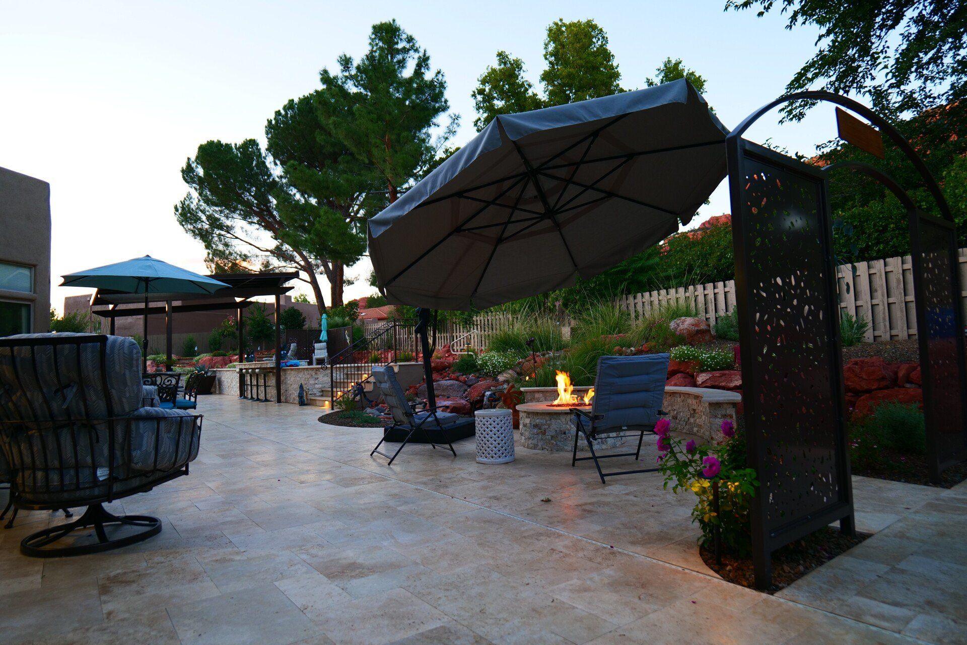 Patio with umbrellas and a fire feature at dusk
