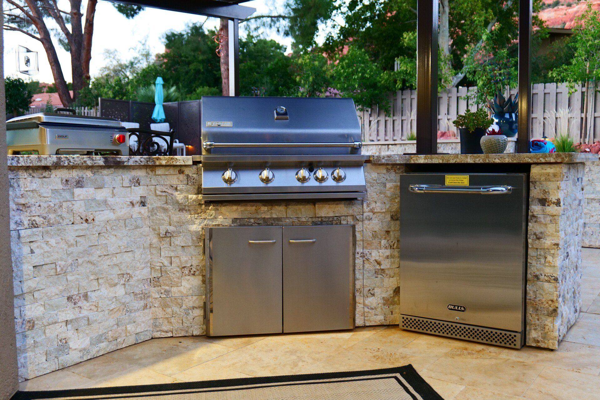 Outdoor kitchen with built-in grill under a ramada