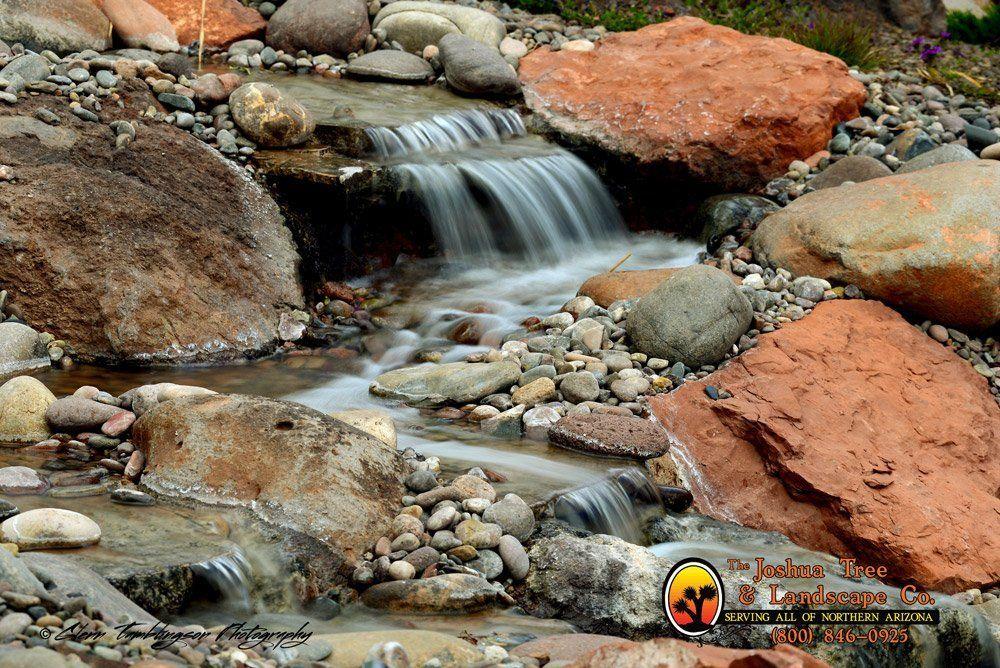 A small waterfall is surrounded by rocks in a rocky area